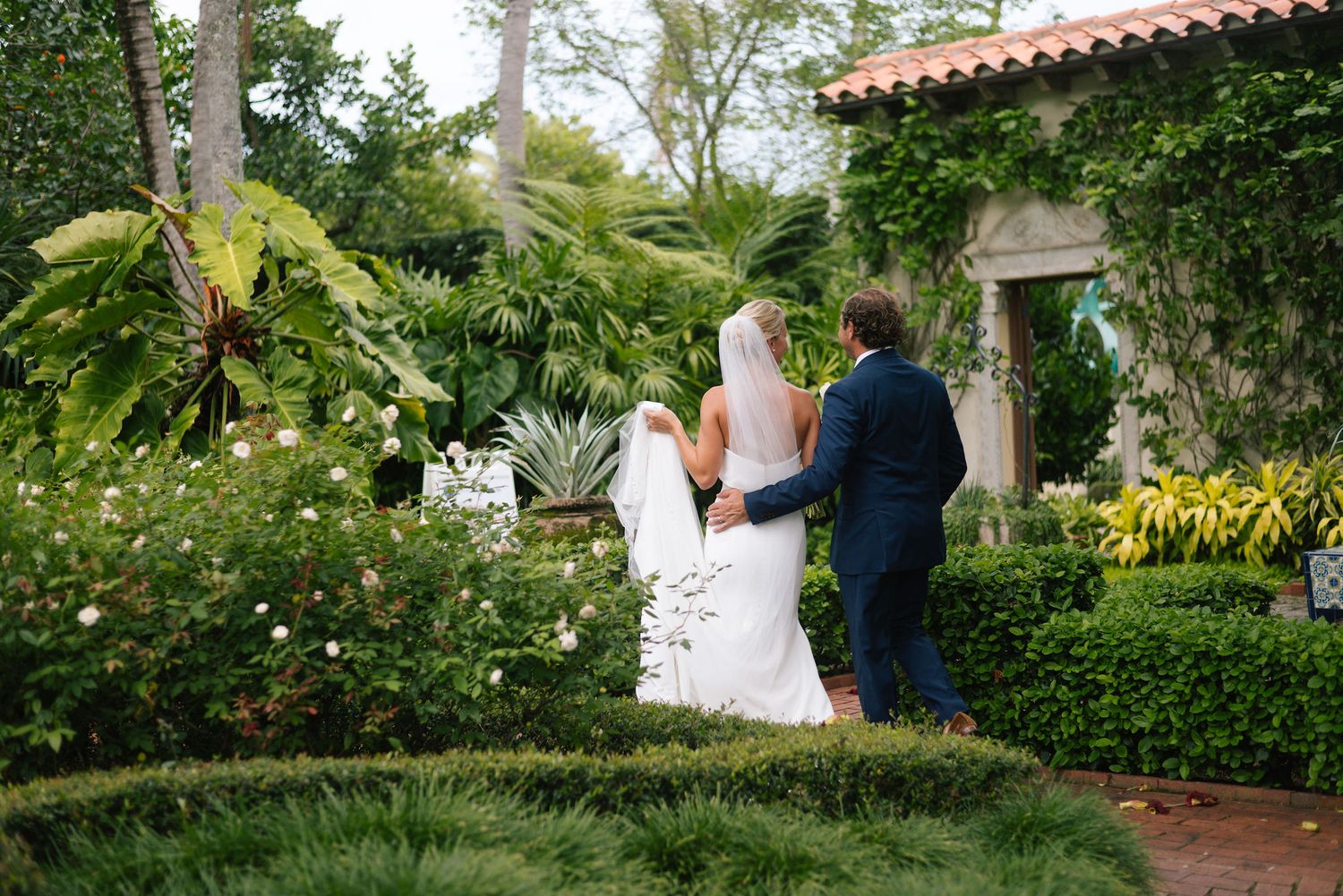 Garden wedding photography session with elegant landscaping and Spanish-style architecture.