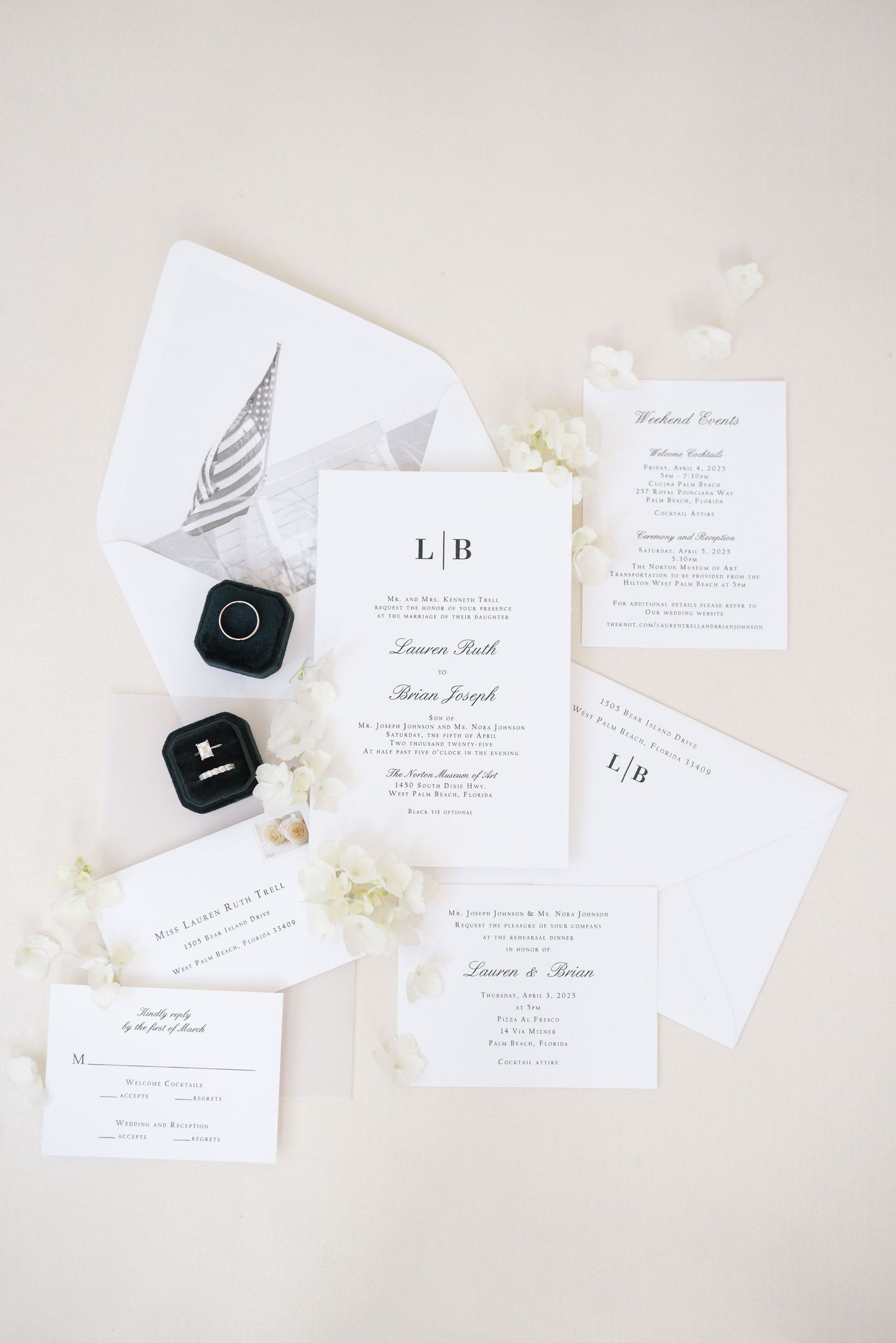 Elegant white wedding invitations and stationery with black ring box arranged on light backdrop in minimalist style.
