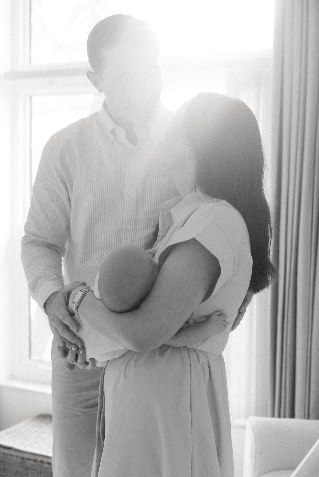 Dreamy backlit family photography in white nursery setting.