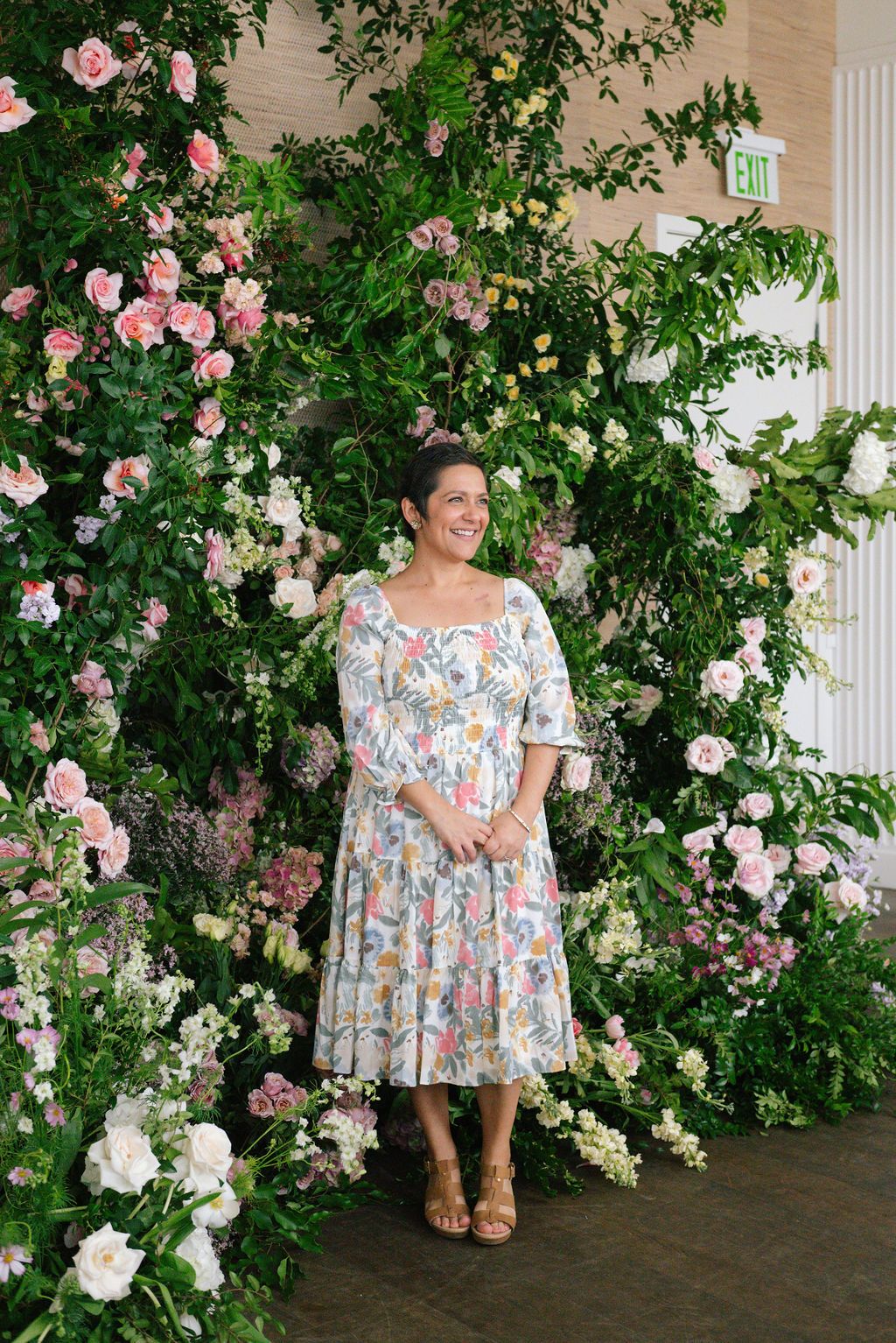 Floral backdrop with climbing pink roses creates romantic setting for spring event photos.