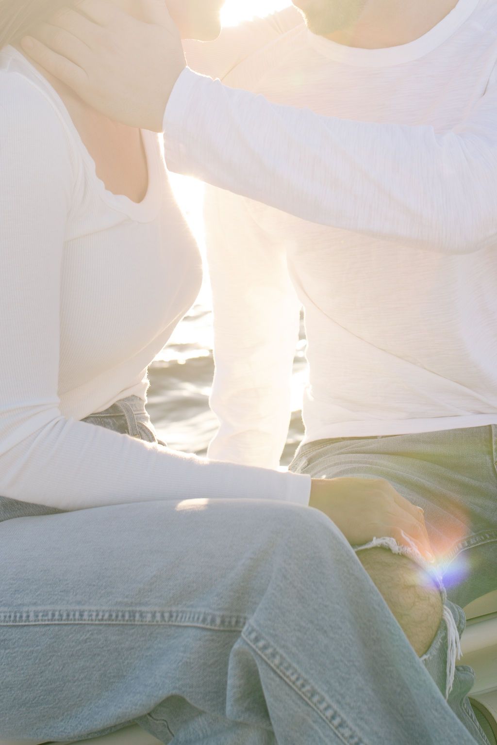 Close-up detail of casual denim and white clothing against boat cushions in natural light.