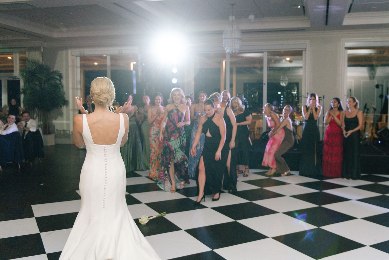 Wedding reception dance floor with guests celebrating under bright venue lighting.