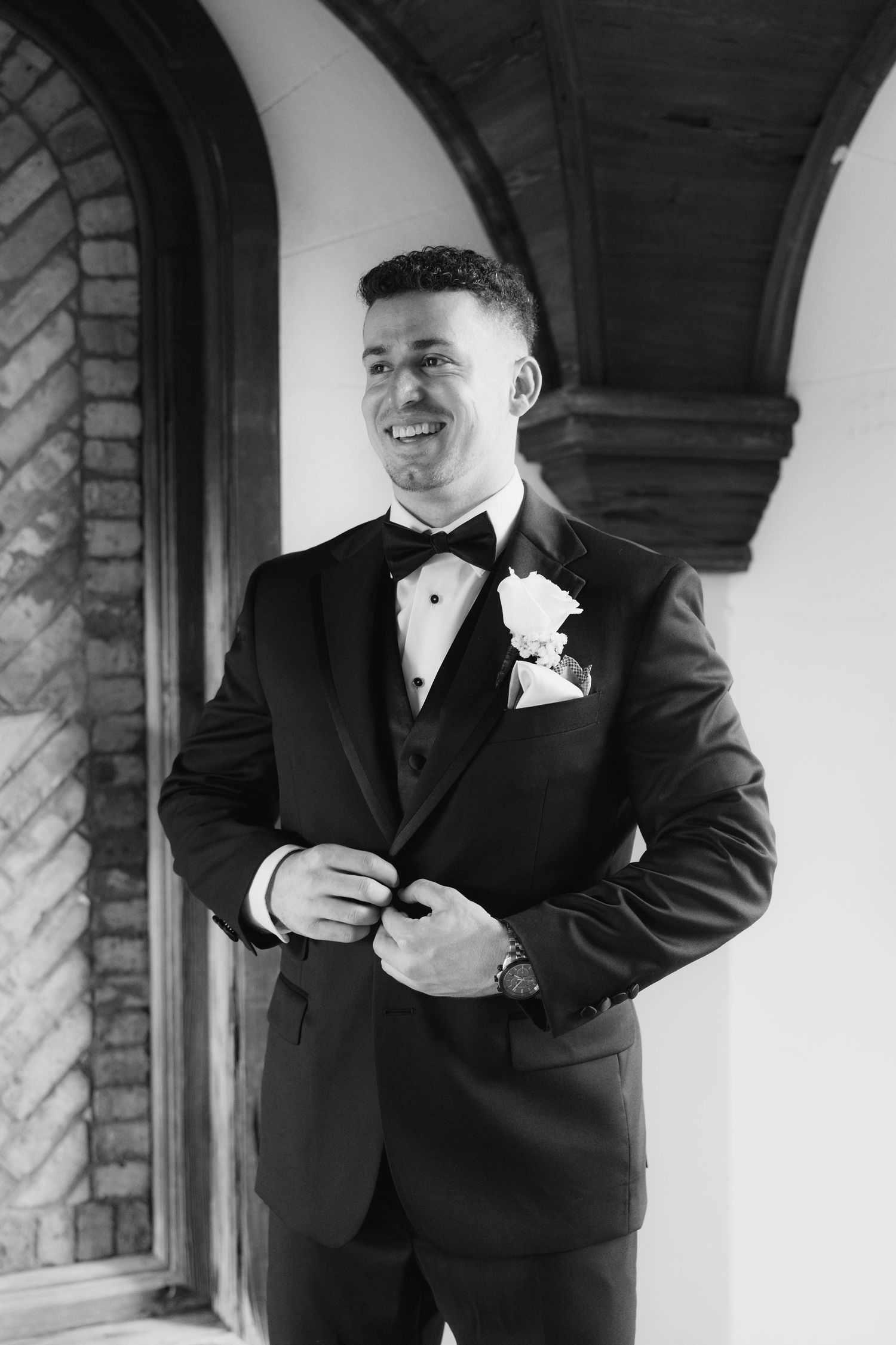 Groom in black tuxedo adjusts his tie and cufflinks in a series of preparation shots.