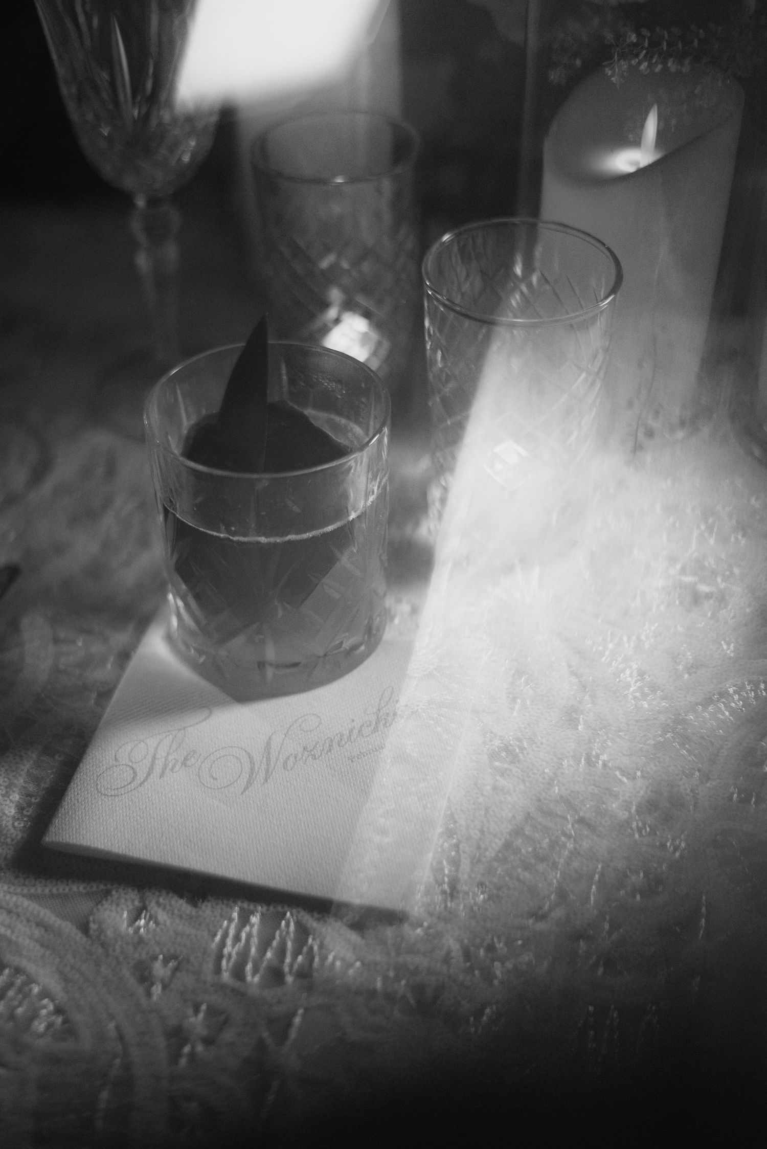 Frosted glass table settings in dramatic black and white lighting.