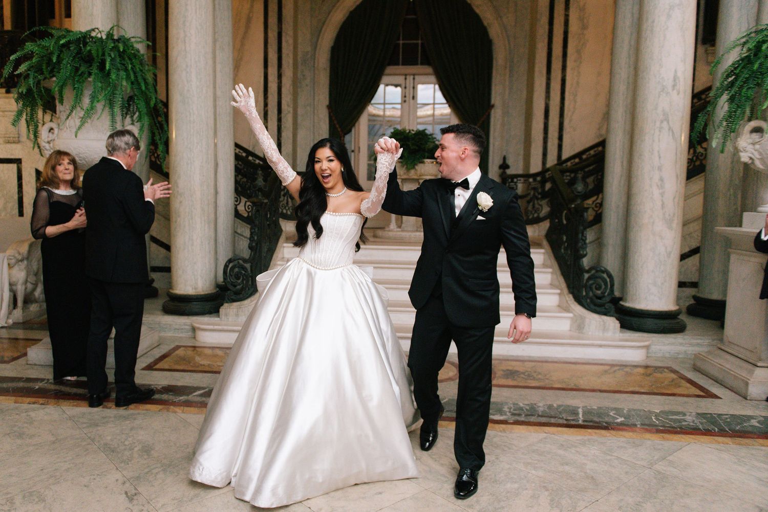 Wedding celebration moment in grand columned venue with elegant decor.
