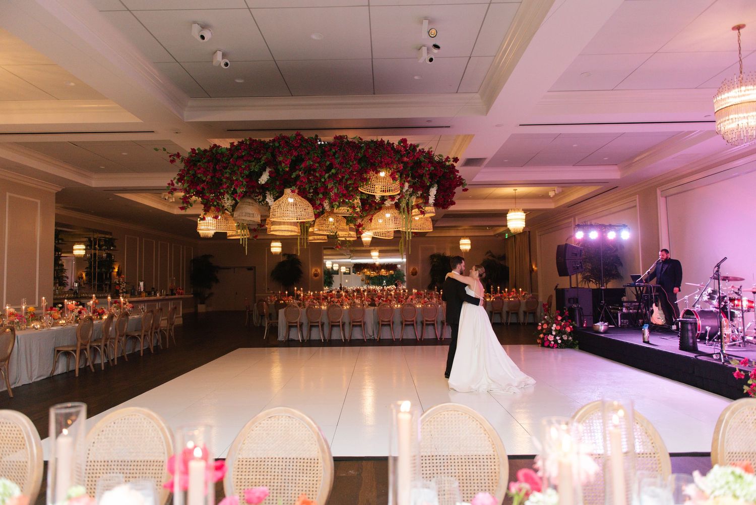 Elegant ballroom decorated with chandeliers and ambient lighting for an evening wedding reception.