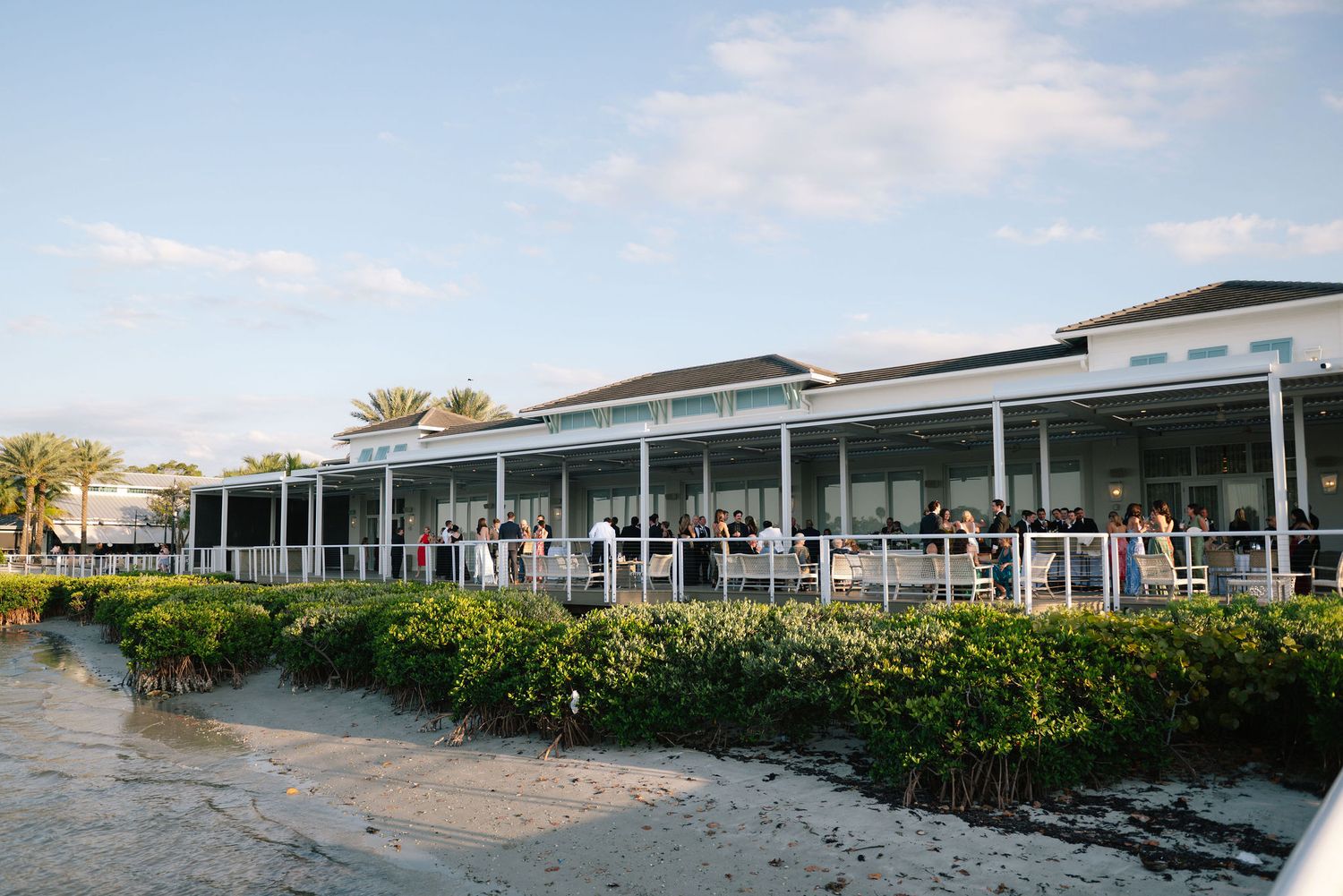 Panoramic view of a modern waterfront wedding venue with white exterior.