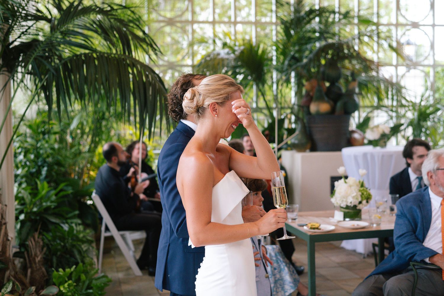 Reception venue with tropical plants and large windows creating a bright, airy atmosphere.