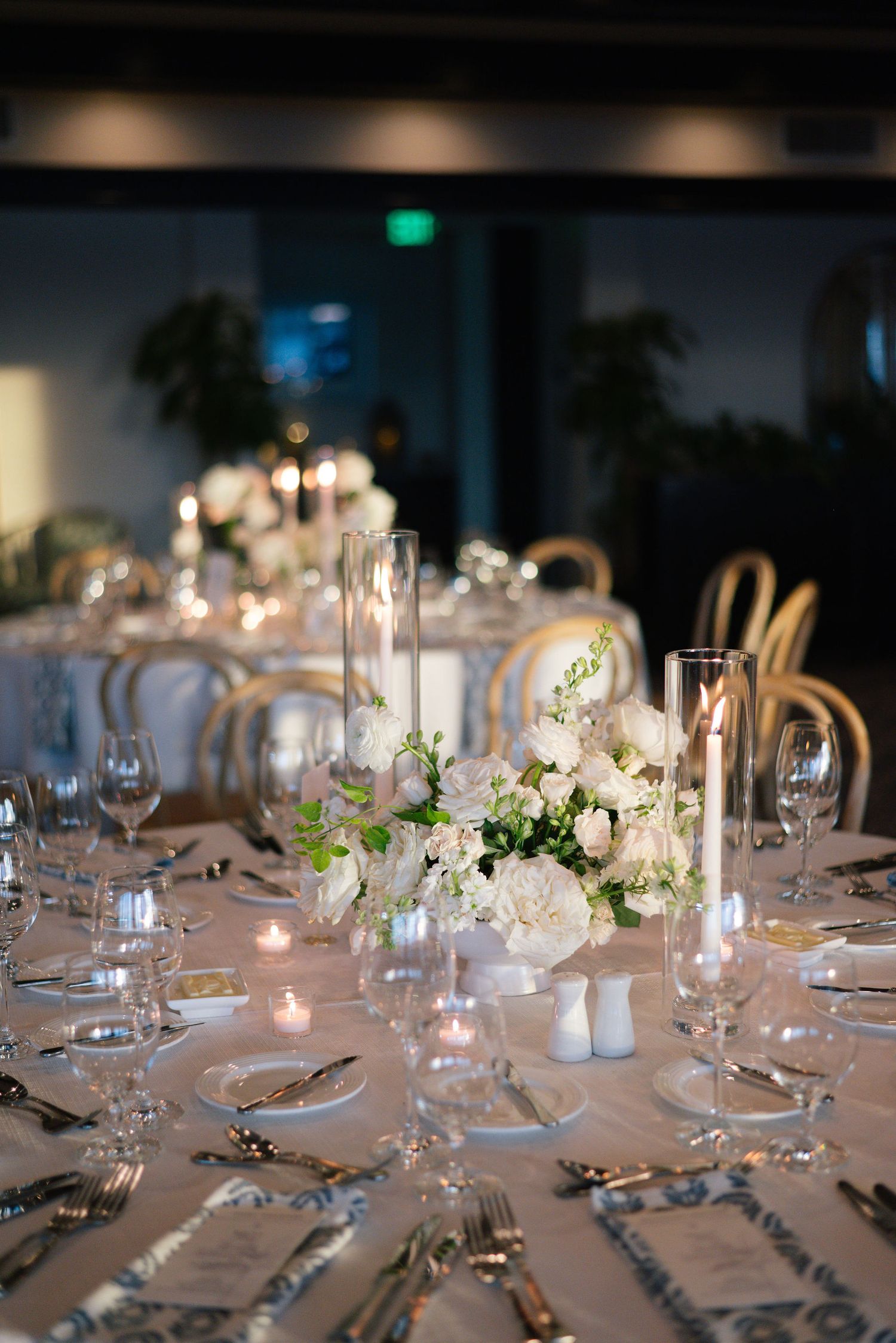 Intimate wedding table settings with white flowers, candles and crystal glassware create an elegant atmosphere.
