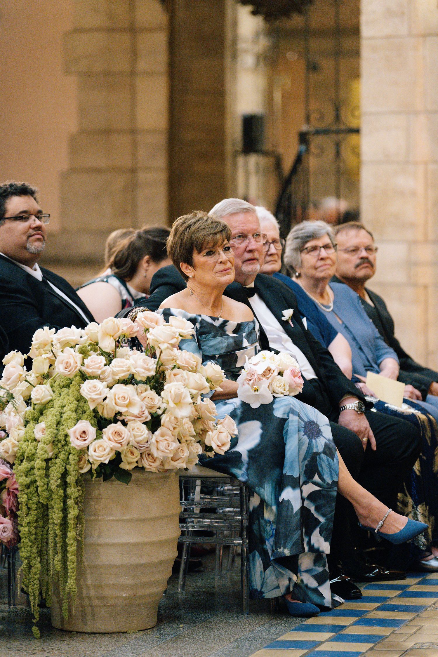Wedding guests seated in rows with elegant floral arrangements decorating the ceremony space.
