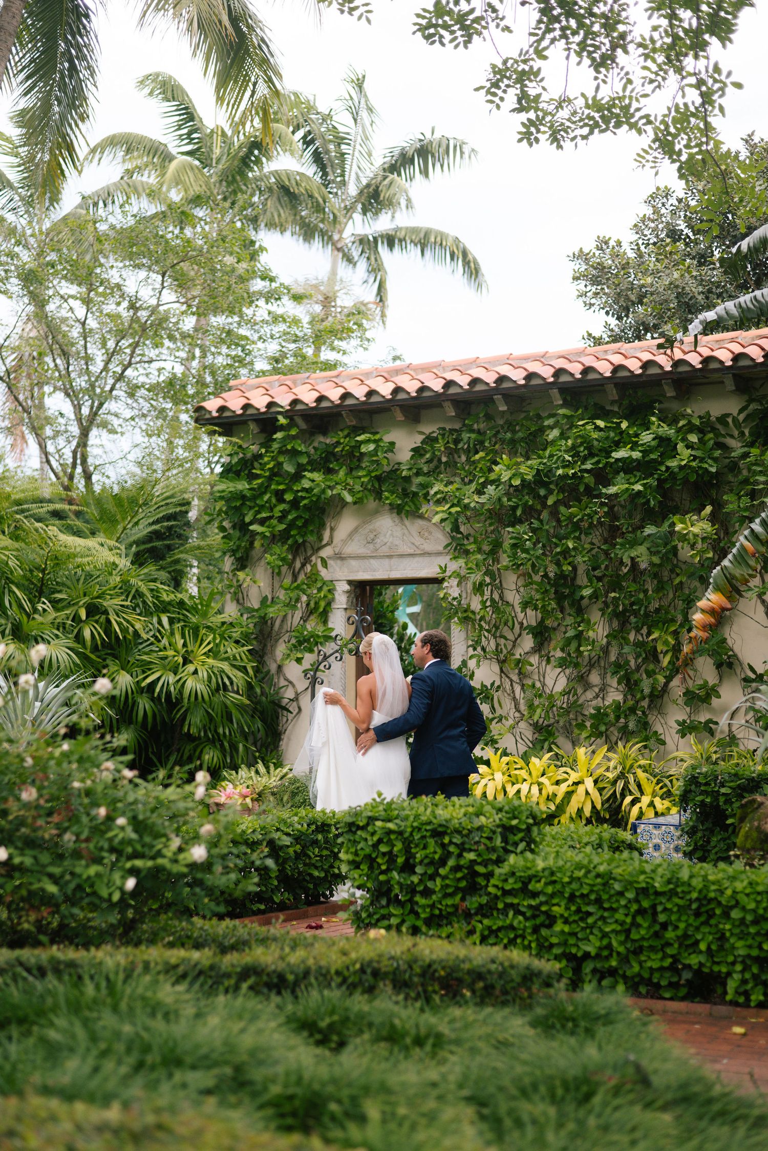 Elegant wedding photography in a tropical garden with Spanish architectural elements.