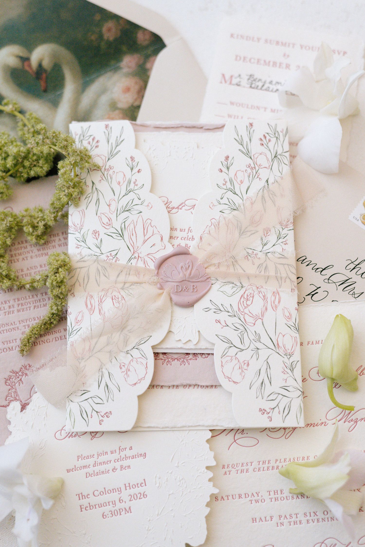 Delicate floral wedding invitations with scalloped edges and botanical illustrations in pink.