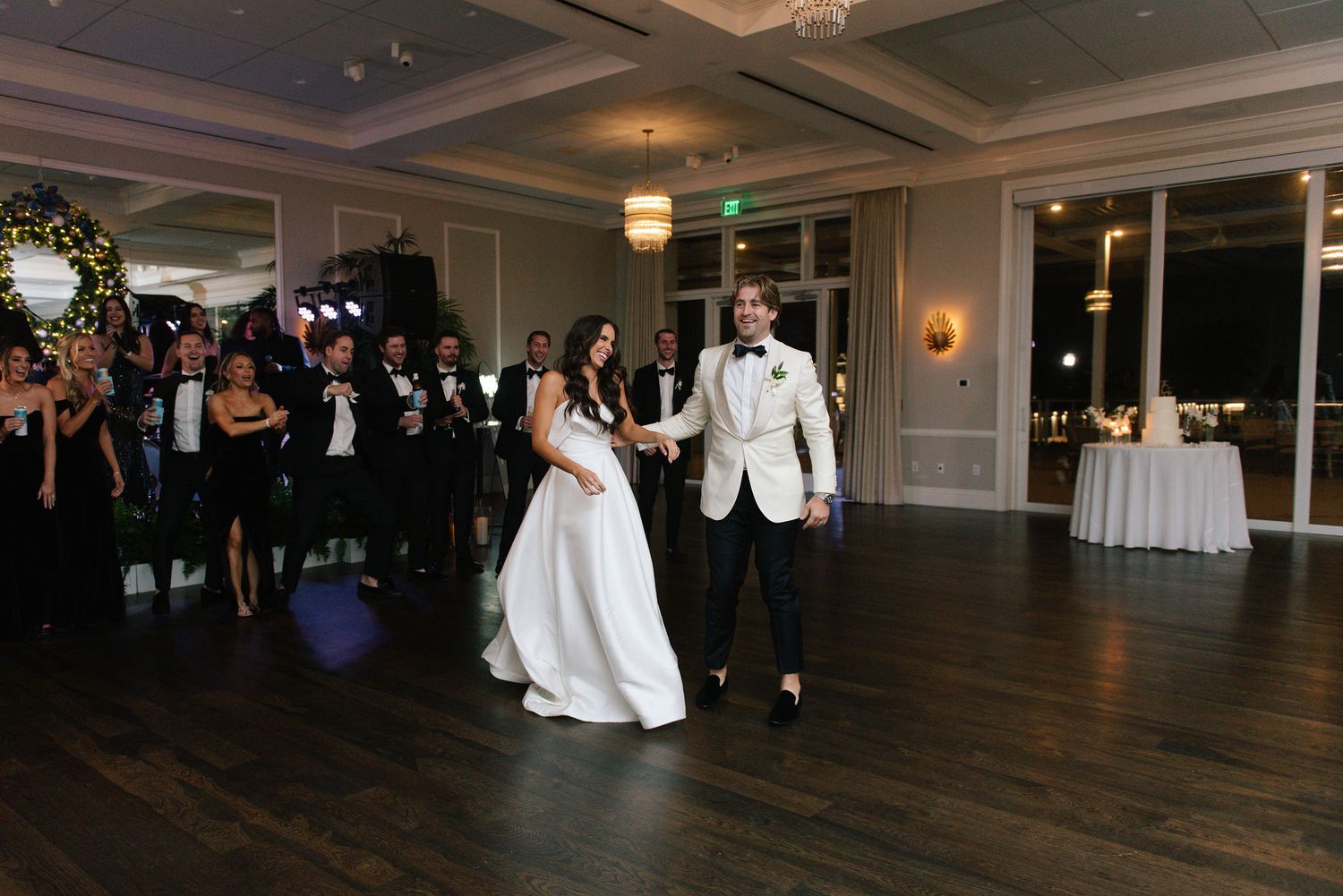Wide view of an elegant ballroom during an evening wedding reception.