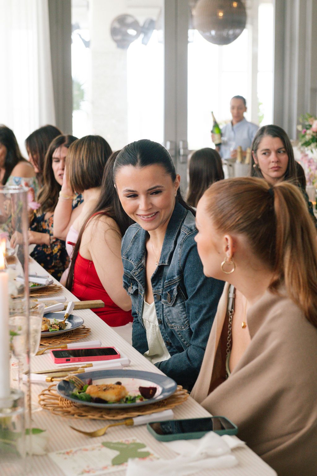 Friends enjoying a meal together at a bright indoor restaurant setting.