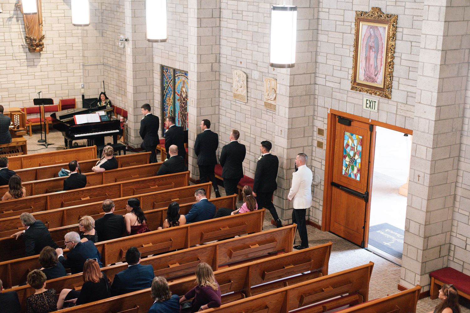 Interior view of a traditional church sanctuary with wooden pews and stone walls during a service.