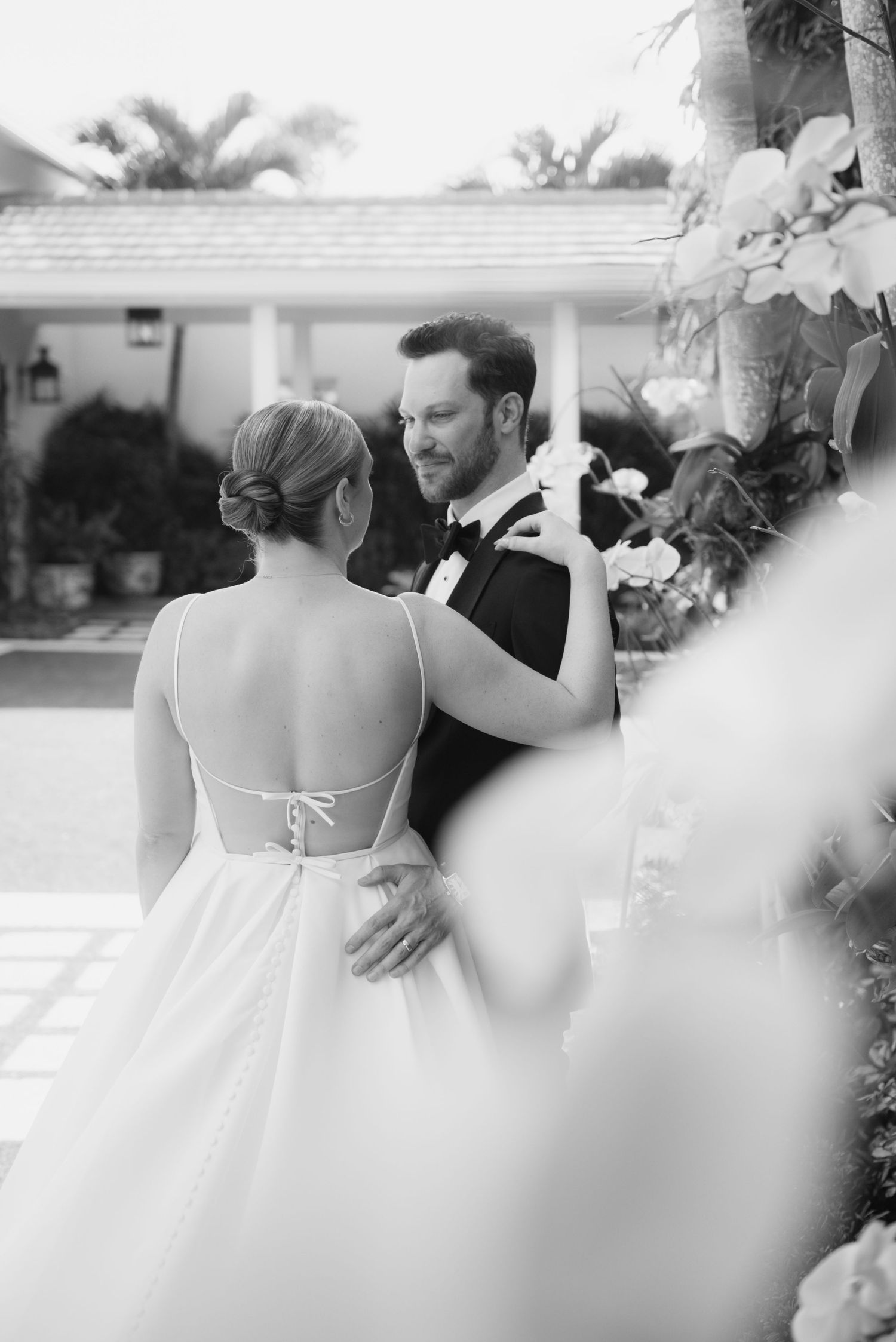 Black and white wedding reception scene with guests mingling and dancing.