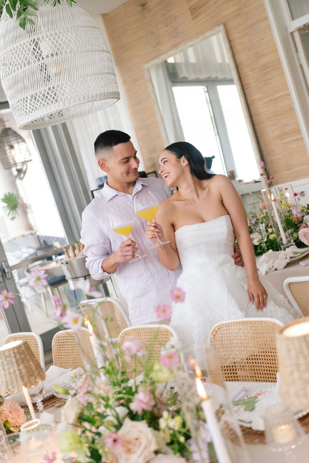 Reception candid moments with rattan decor and hanging woven pendant lights.