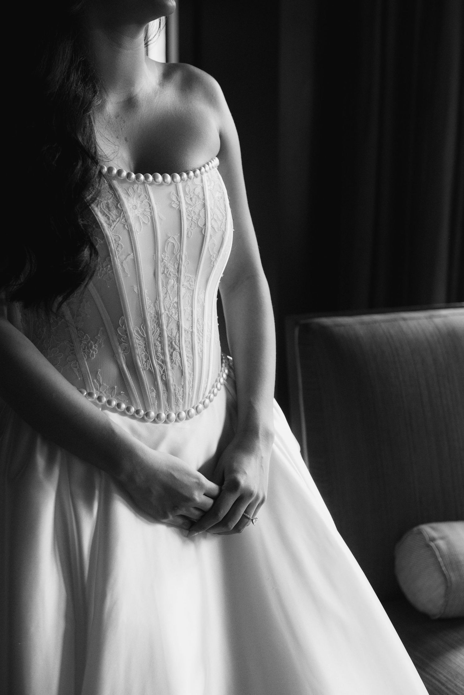 Black and white detail shots of a structured white corset dress with button details.