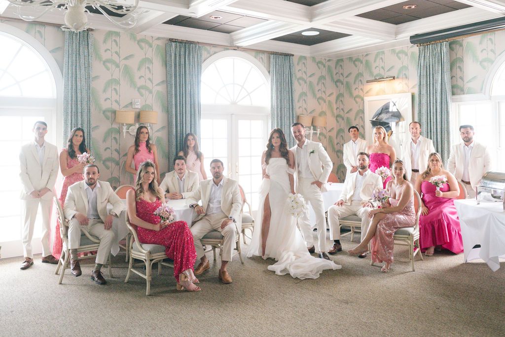 Wedding party relaxing in an elegant room with blue and floral wallpaper.