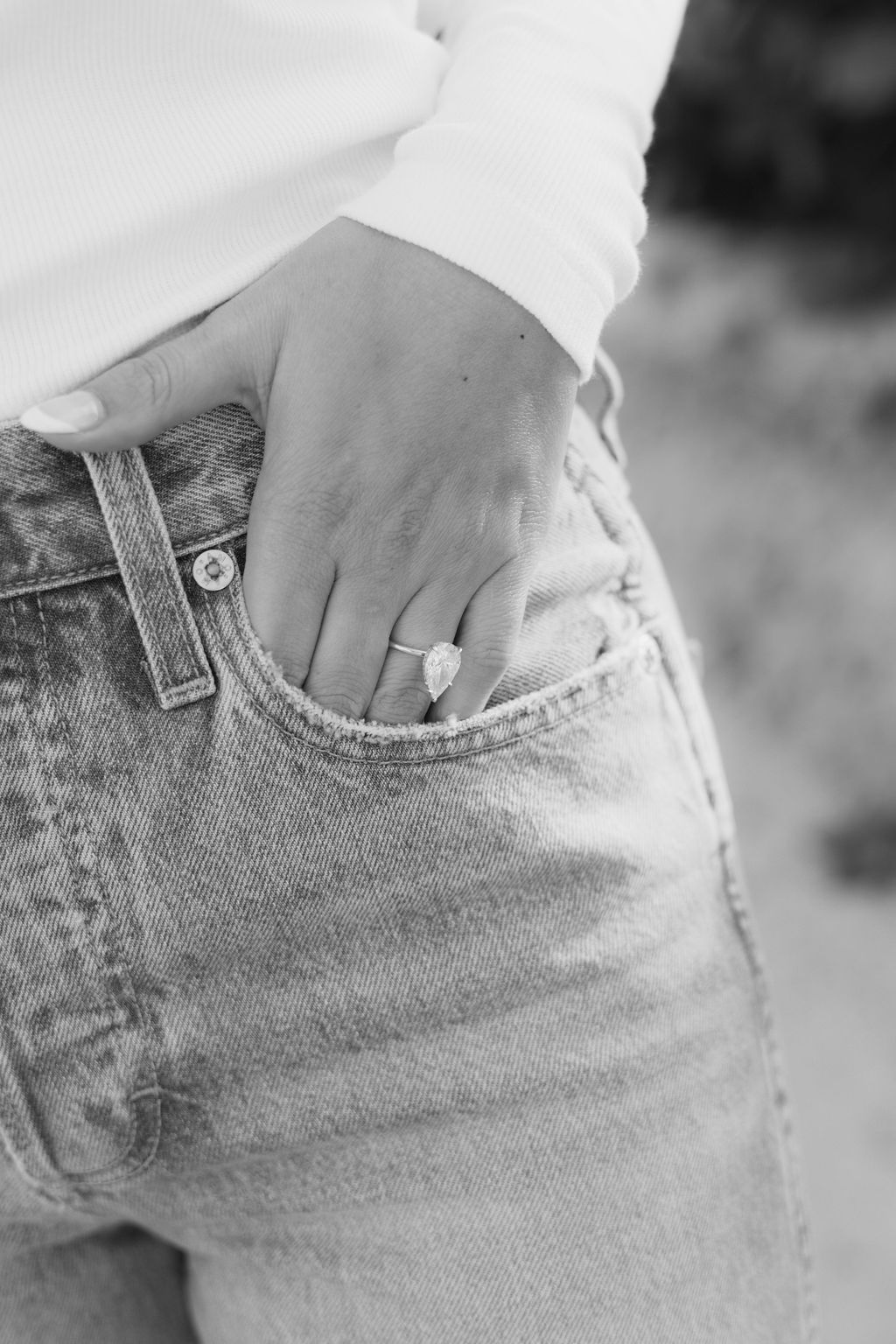 Close-up of hands in denim jean pockets in black and white photography.