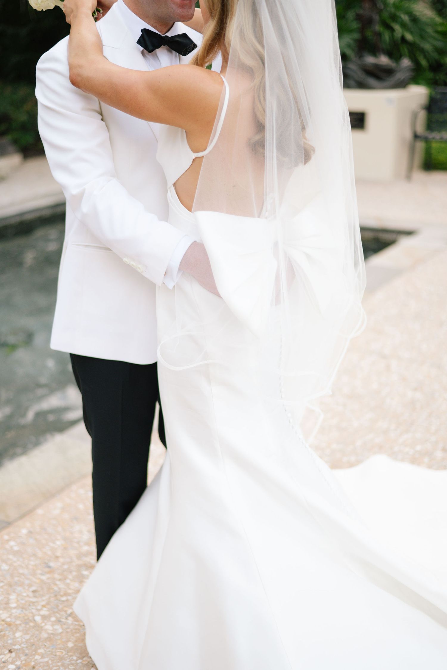 Romantic wedding couple dancing together on a paved outdoor terrace.