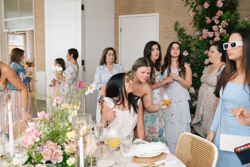 Guests mingling and socializing at an upscale brunch party with floral decorations.