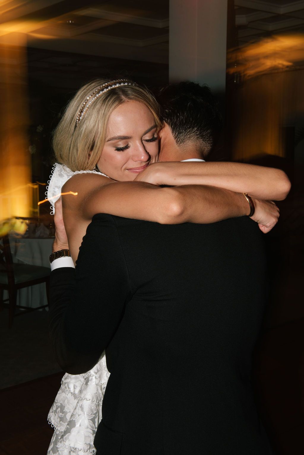 A couple shares a romantic dance embrace during their wedding reception.