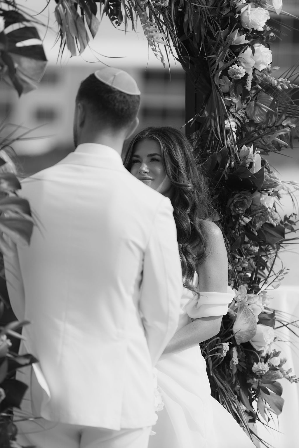 Black and white wedding photos showing close-up details of floral arrangements and decor.
