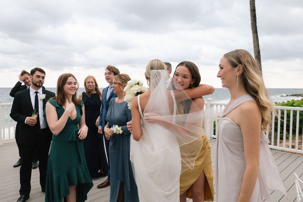 Celebratory gathering on an oceanfront balcony with formal attire.