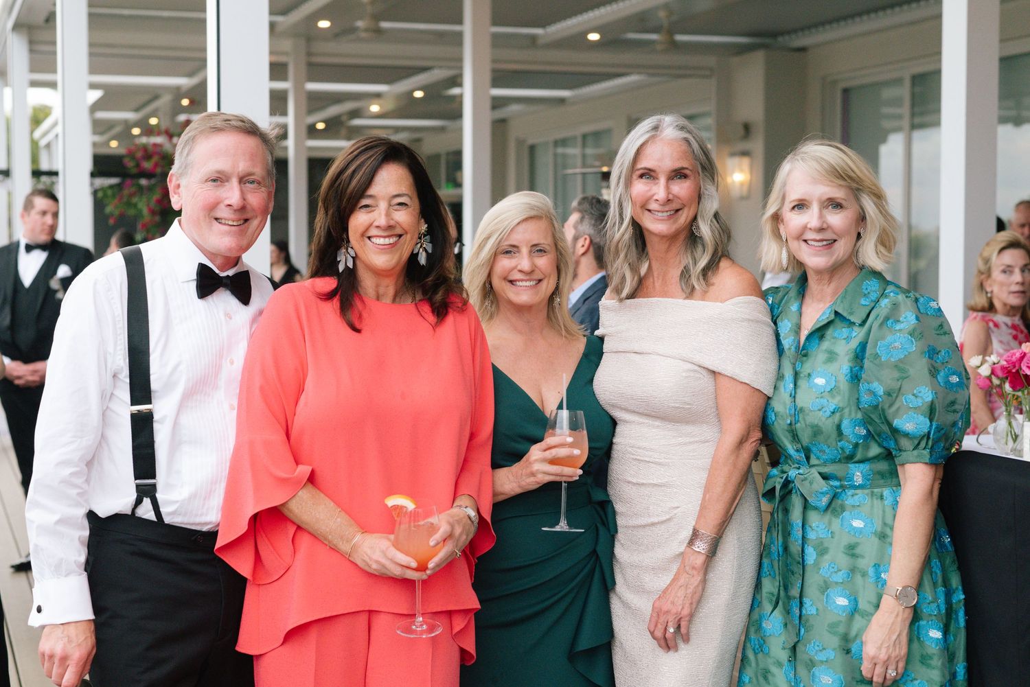 Wedding guests in colorful attire gathered for a celebration photo.