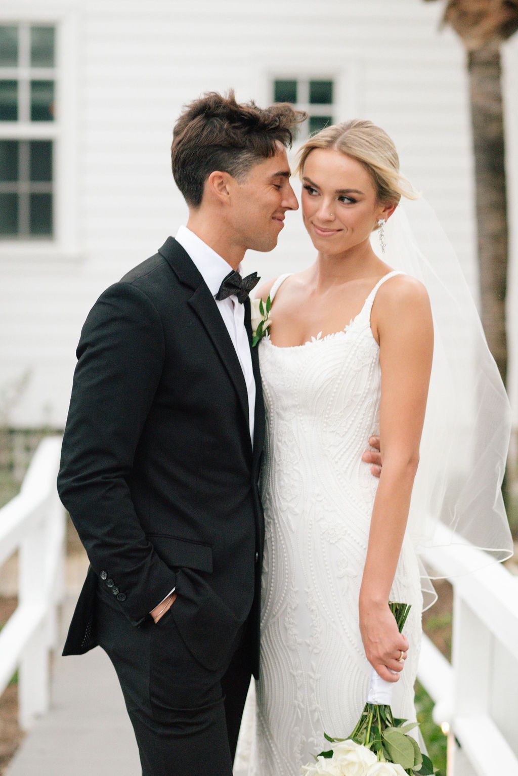 Romantic wedding portraits against white coastal architecture.