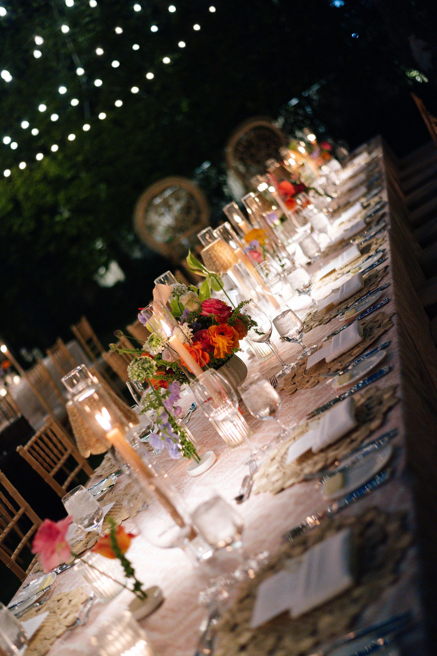 Elegant wedding reception table setting with string lights overhead creating a romantic ambiance.