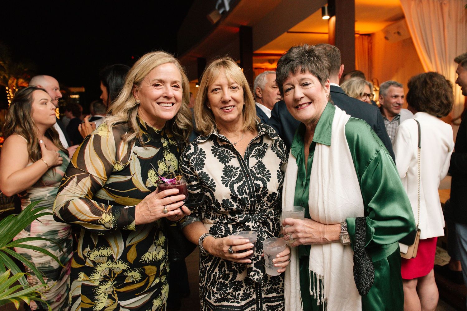 Guests celebrating at an elegant evening wedding reception with warm lighting.