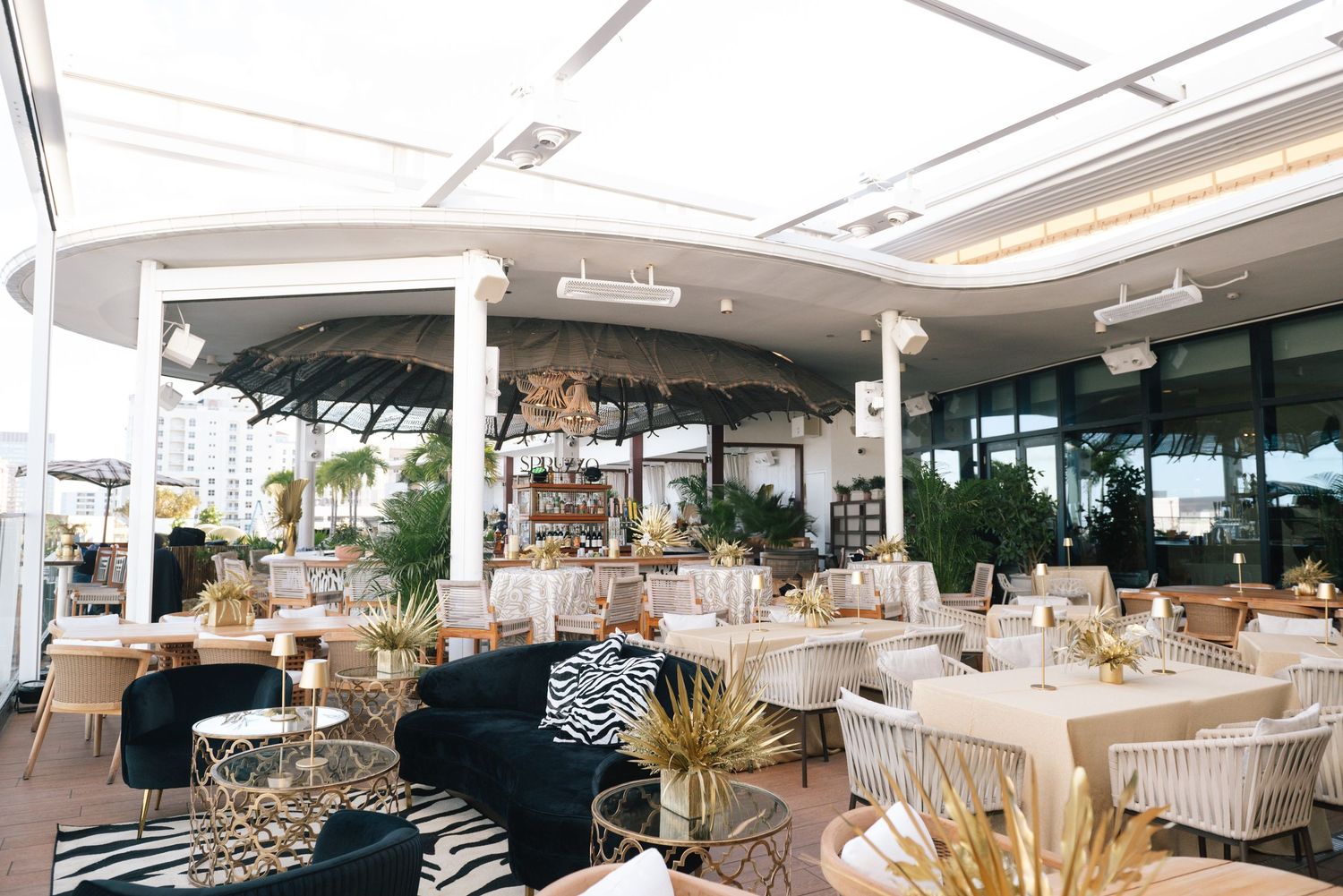 Modern wedding venue interior with elegant white decor and panoramic windows showcasing natural light.