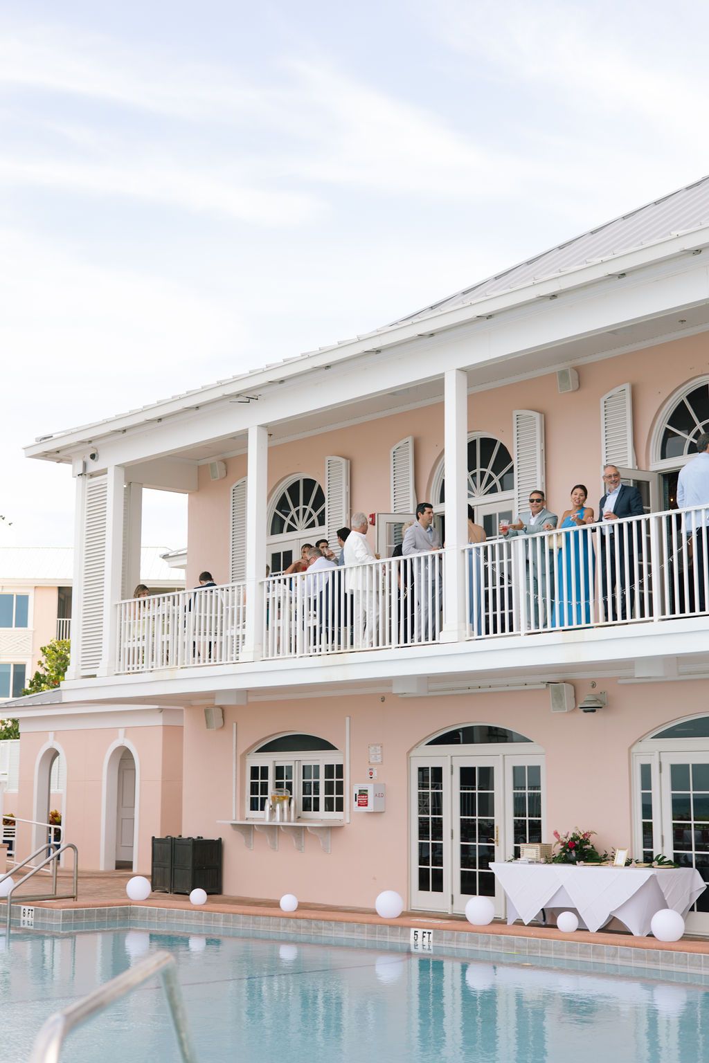 Pink beachfront venue with white balconies and a swimming pool overlooking the ocean.