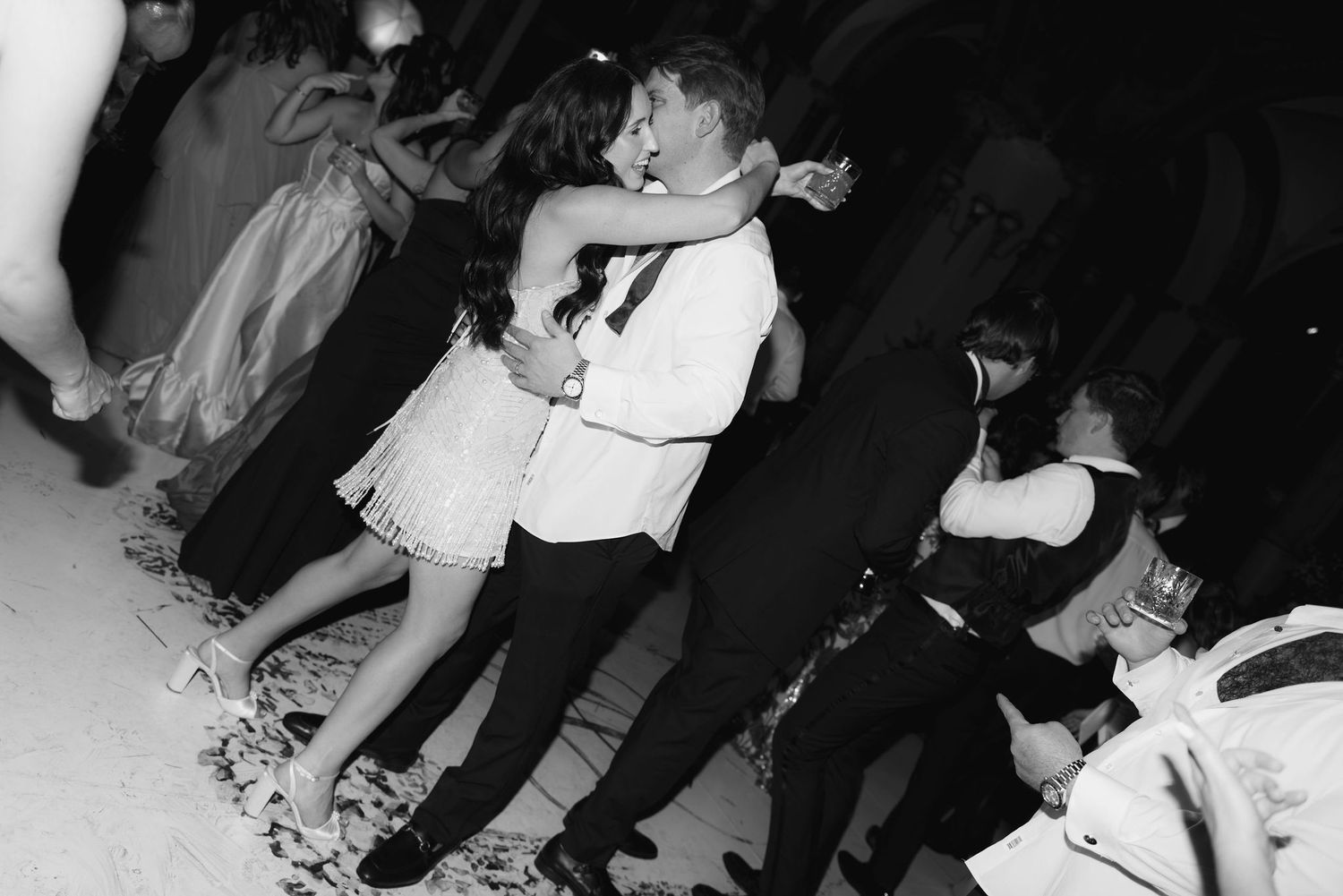 Black and white photo of guests dancing at an elegant wedding reception.