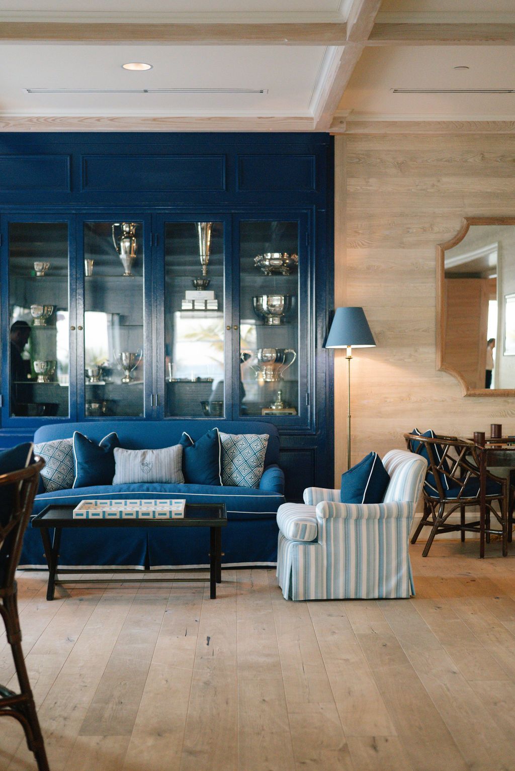 Elegant living room with navy blue display cabinet, matching sofa, and hardwood flooring.