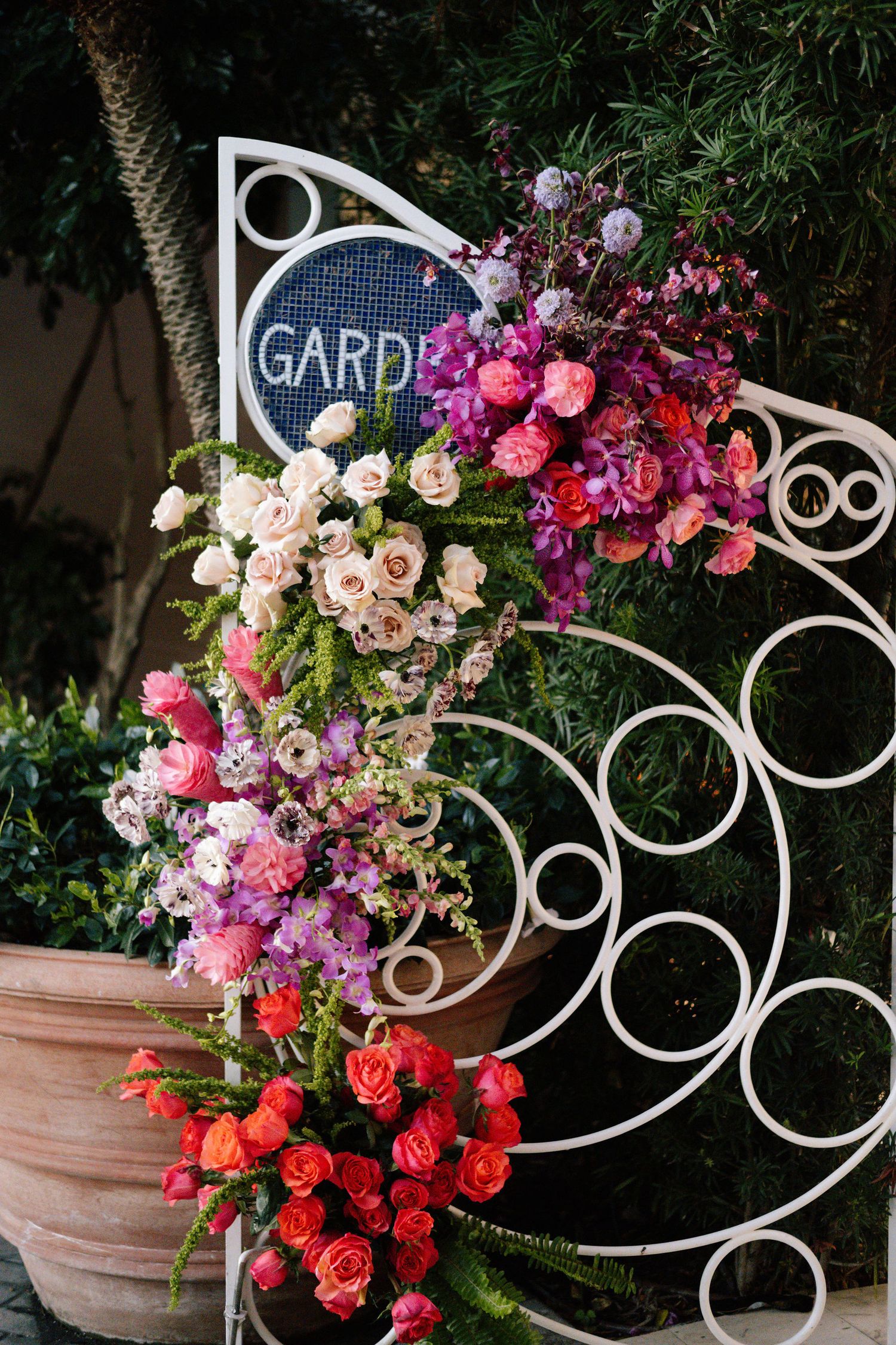 Decorative garden gate with vibrant pink and purple floral arrangements.