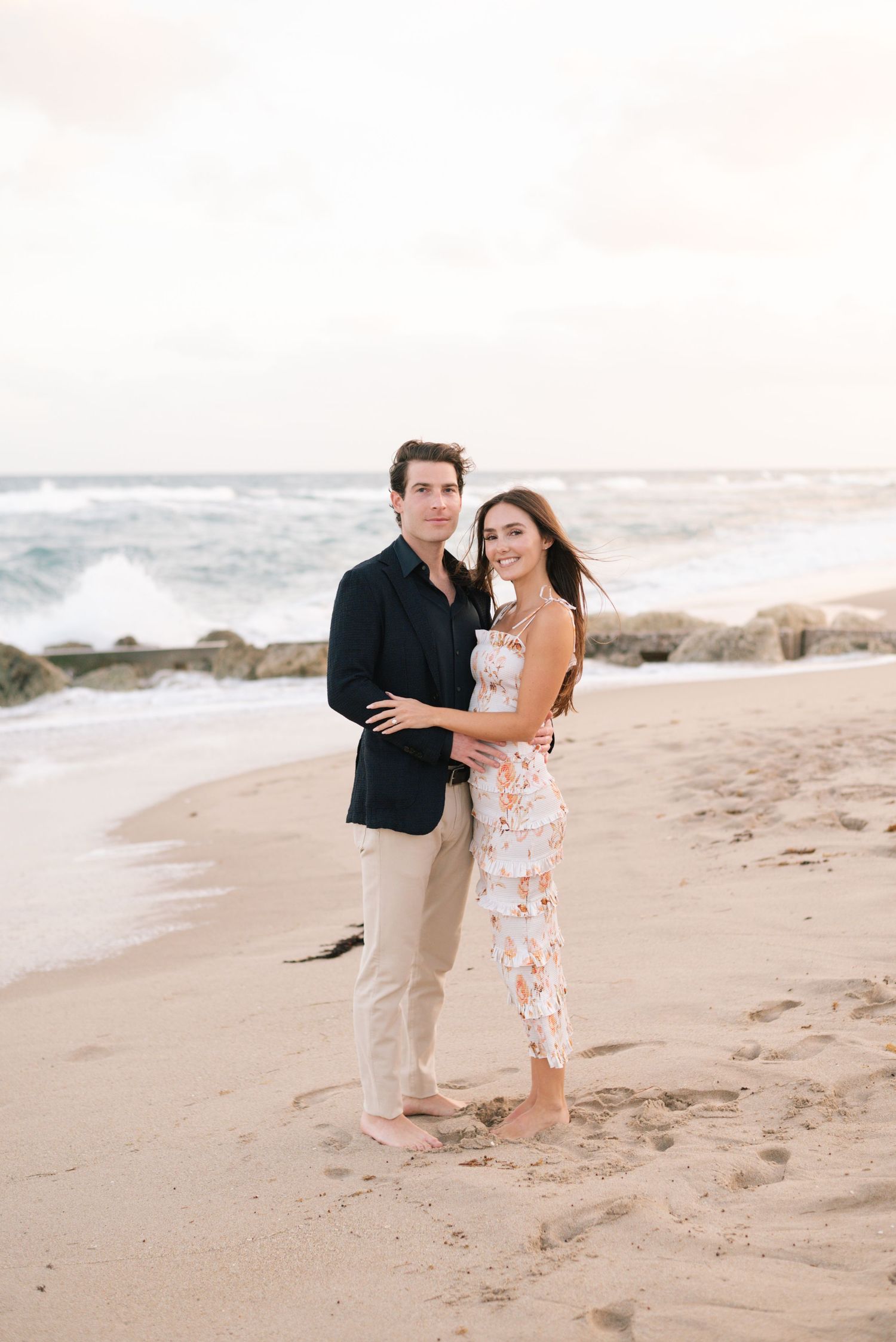 Couple sharing intimate moment on sandy beach at sunset.