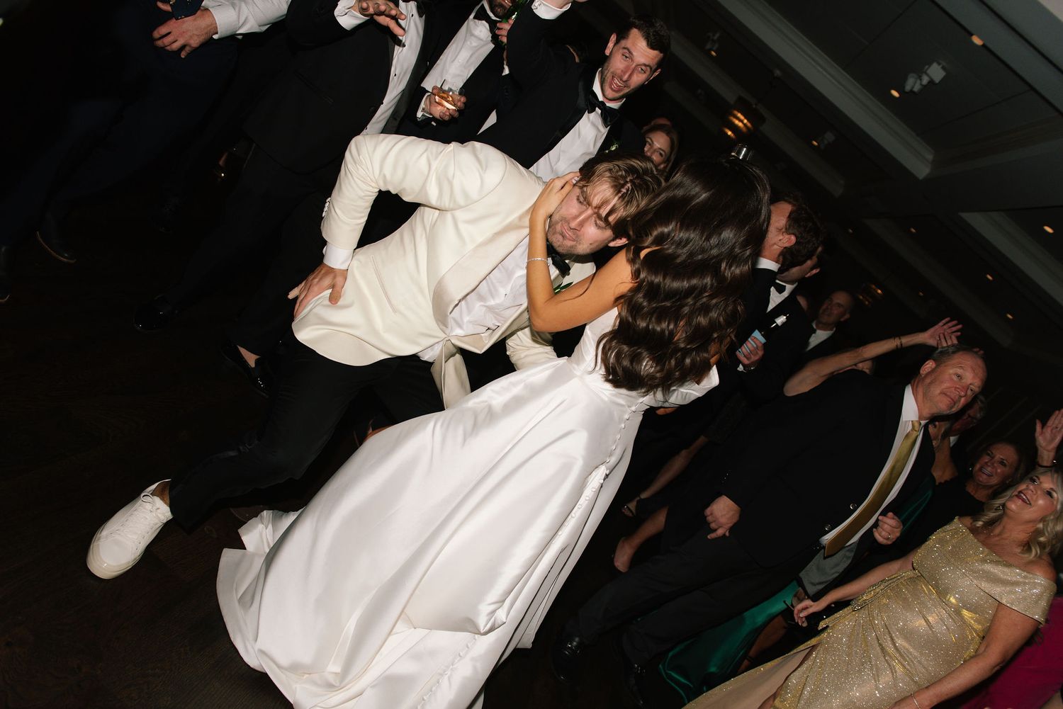 Dynamic dance moves captured during a wedding reception celebration.