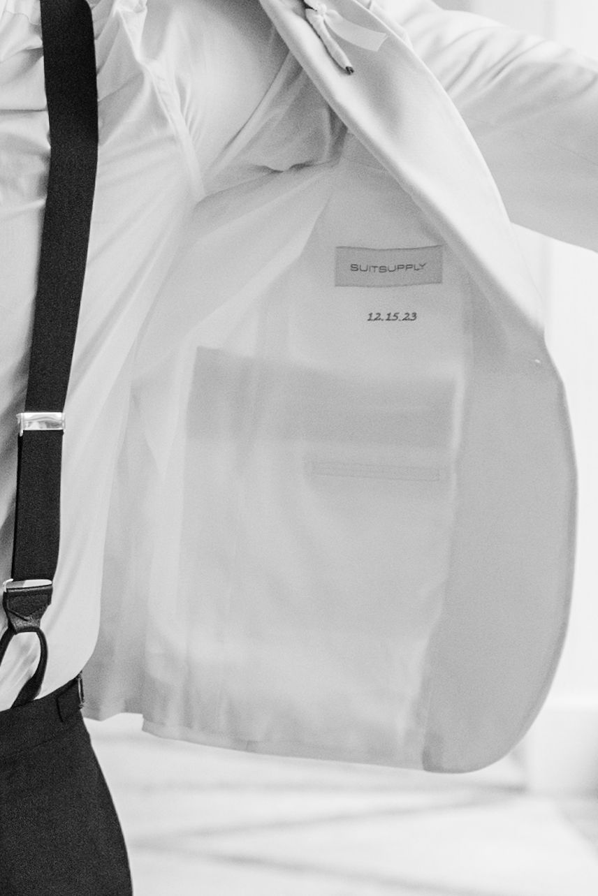 Close-up detail of formal attire showing suspenders and white shirt fabric.