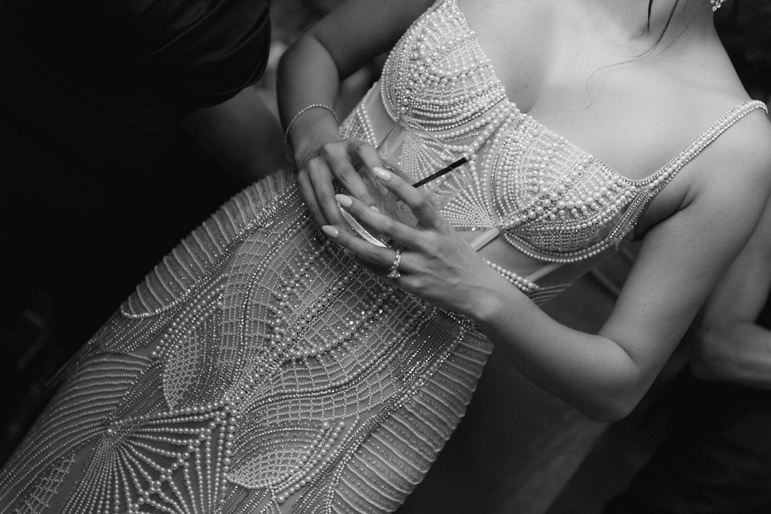 Close-up details of an intricately beaded wedding dress bodice in silver and white.