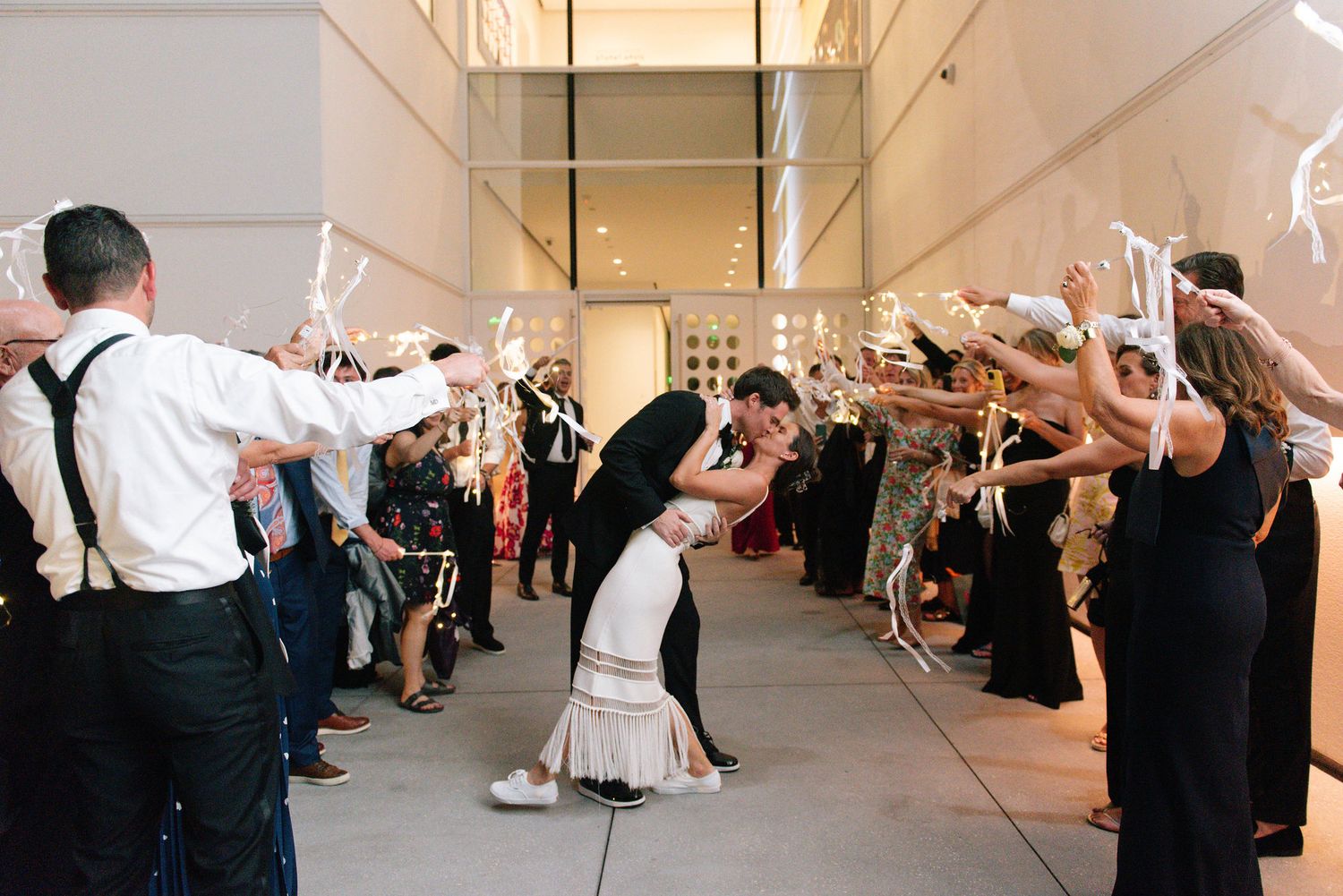 Wedding celebration with guests forming a tunnel of sparklers for a grand exit.