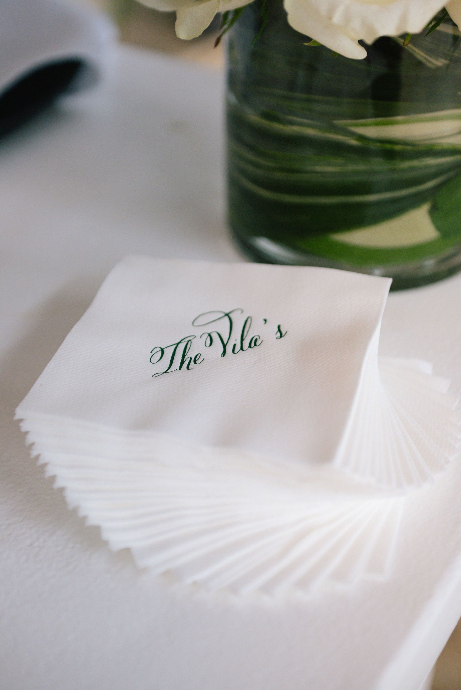 White folded paper napkins with elegant calligraphy text arranged in a row.