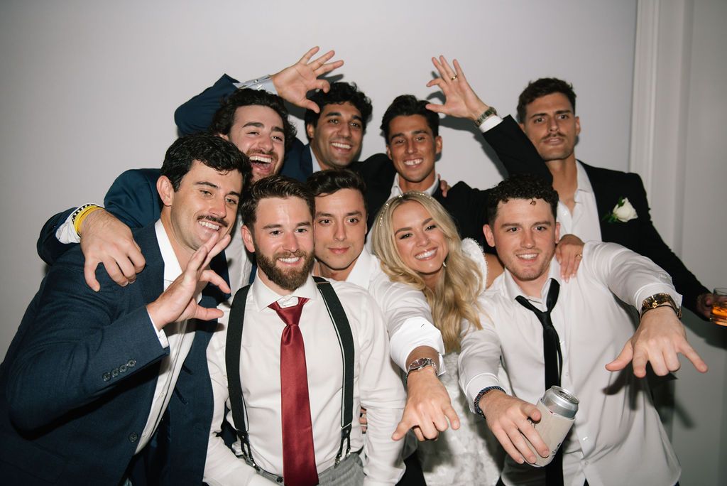 Wedding party members pose together for a fun group photo at the reception.