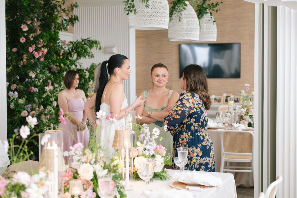 Wedding reception venue decorated with pink florals and modern coastal elements.