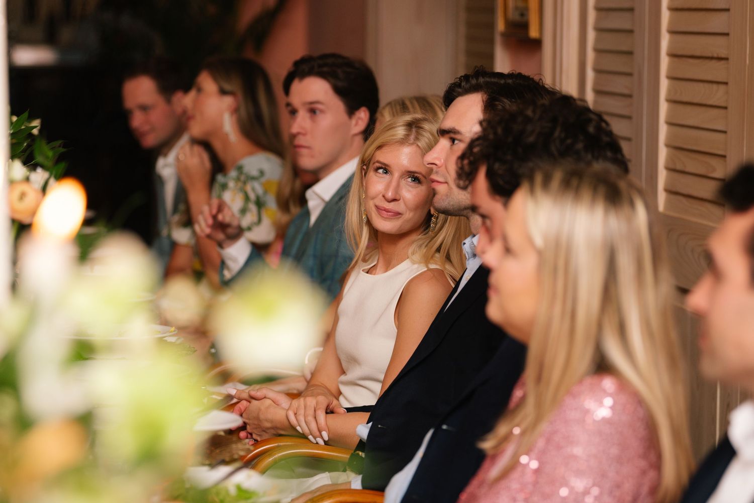 Wedding reception guests seated at tables during evening celebration.