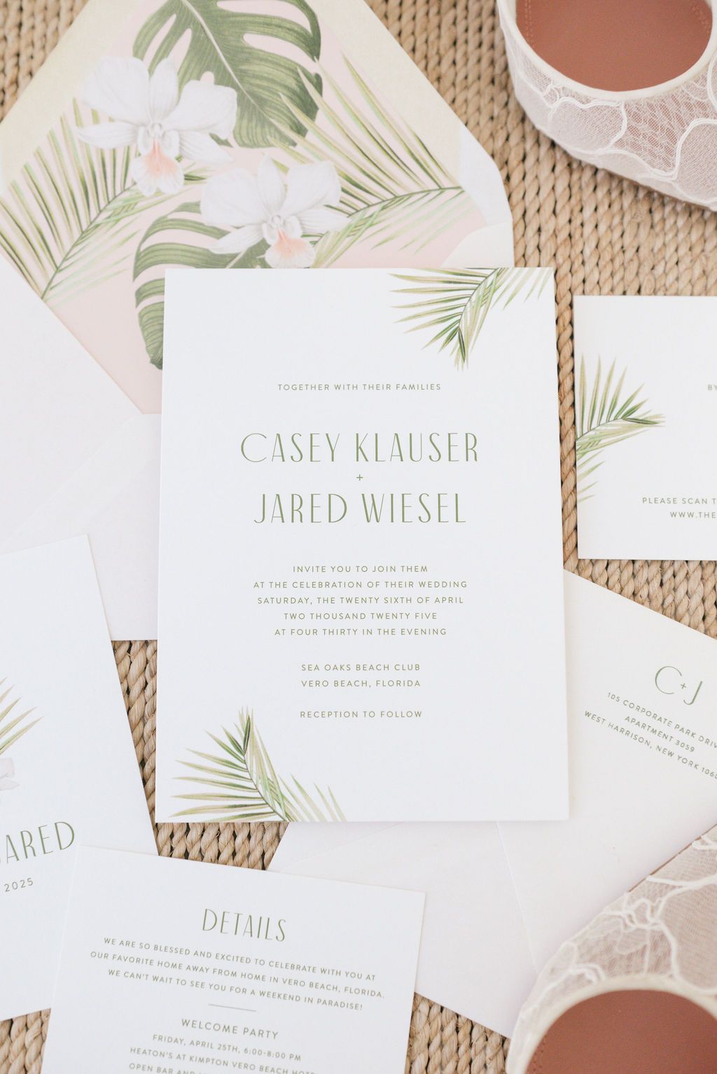 Tropical wedding invitations with palm leaf design and elegant typography on textured background.