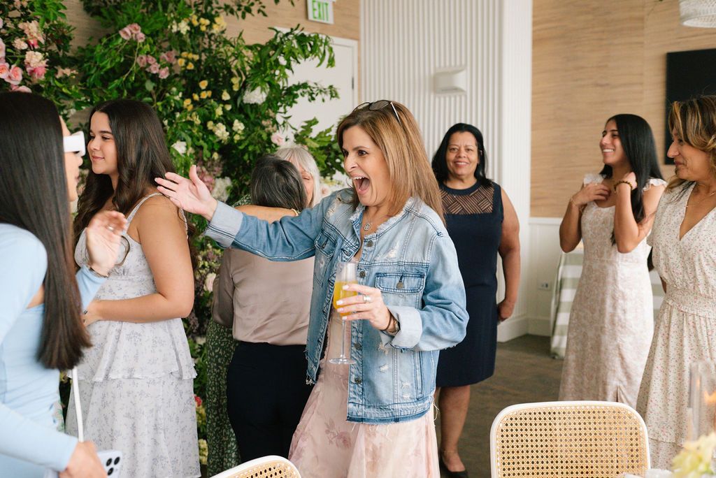 Guests enjoying a celebratory brunch gathering with mimosas and conversation in a bright modern dining space.