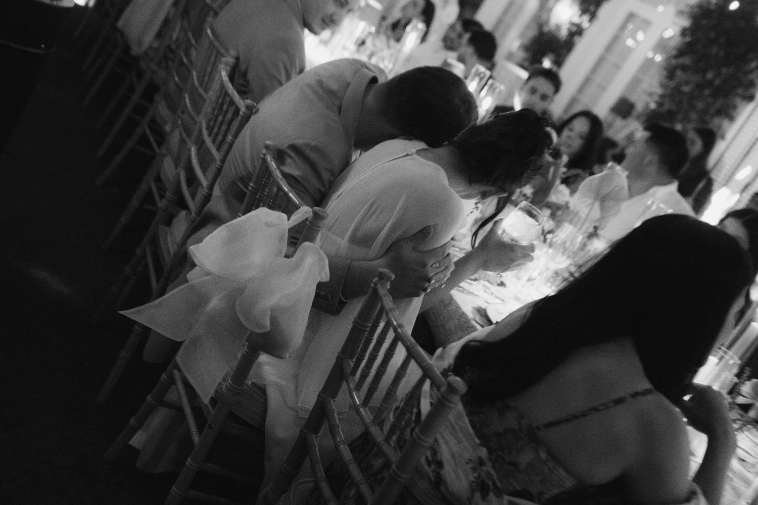 Black and white photo of guests seated at an elegant outdoor dinner reception.